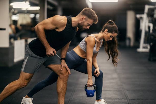 Coach helping a client with kettlebell form
